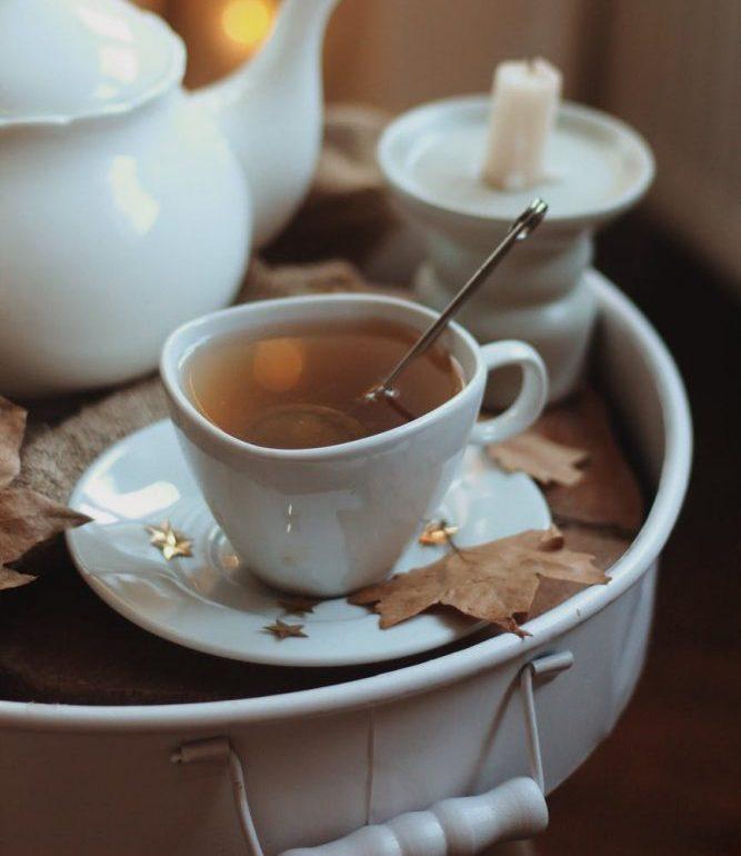 a high angle view of a tea in a cup next to a porcelain teapot